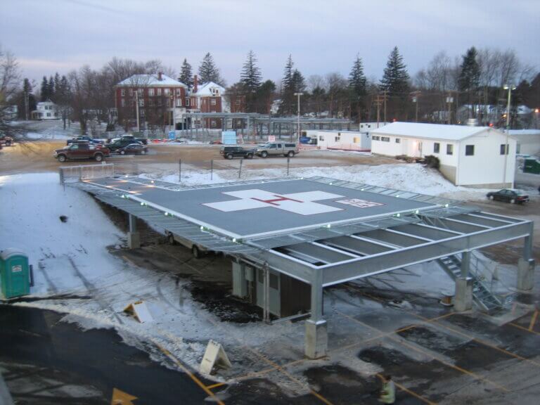 Elevated hospital helipad with aluminum decking, perimeter lighting, and integrated snowmelt system keeping the landing surface clear in winter conditions