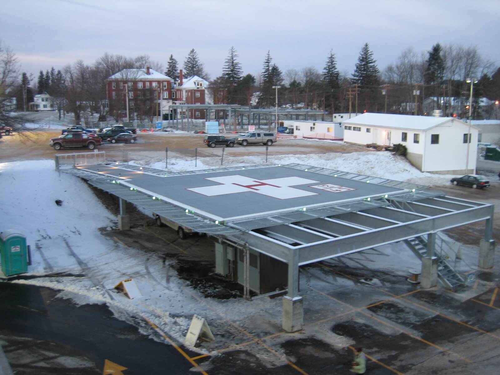 Elevated hospital helipad with aluminum decking, perimeter lighting, and integrated snowmelt system keeping the landing surface clear in winter conditions