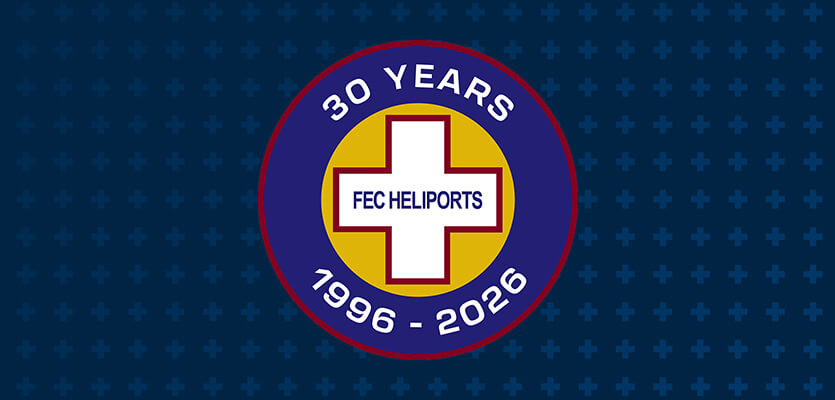 30-year anniversary badge for FEC Heliports featuring a red and blue circular seal with a white cross and the text “FEC Heliports 1996–2026.”